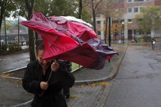 A woman tries to take cover from rain in Hoboken while Hurricane Sandy approaches New Jersey, October 29, 2012. Hurricane Sandy, the monster storm bearing down on the U.S. East Coast, strengthened on Monday after hundreds of thousands moved to higher ground, public transport shut down and the U.S. stock market suffered its first weather-related closure in 27 years. REUTERS/Eduardo Munoz (UNITED STATES - Tags: ENVIRONMENT DISASTER) Published: Říj. 29, 2012, 6:27 odp.