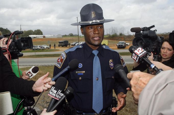 Alabama State Trooper Charles Dysert speaks to the media near the scene of a shooting and hostage taking in Midland City, Alabama, January 30, 2013. A gunman boarded an Alabama school bus ferrying children home from school on Tuesday and fatally shot the driver before fleeing with a young child and holing up in an underground bunker, Alabama media reported. Sheriff's officials confirmed that one person had been killed in a shooting involving a school bus in Alabama's Dale County but gave scant details other than to say that a child was present at the scene in Midland City. REUTERS/Phil Sears (UNITED STATES - Tags: CRIME LAW) Published: Led. 30, 2013, 10:51 odp.