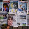 A worker arranges the front pages of Spanish newspapers paying tribute to late soccer legend Diego Maradona at Las Ramblas, in Barcelona