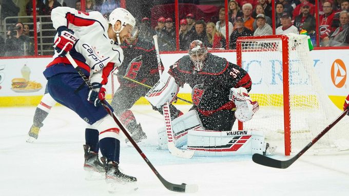 Brankář Caroliny Petr Mrázek úspěšně čelí v utkání play off NHL nájezdu Jevgenije Kuzněcova z Washingtonu