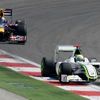 Jenson Button uniká na trati Sebastianu Vettelovi