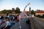 Asi čtyři stovky Pražanů v úterý společně přivítaly první letní den ranní jógovou lekcí na Karlově mostě.