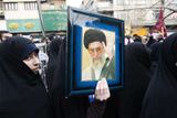 Žena na vládou organizované demonstraci drží v rukou fotku ajatoláha Chameneího.