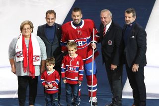 Tomáš Plekanec se stříbrnou hokejkou, kterou obdržel za 1000 zápasů v NHL. Společně s českým hokejistou jsou na fotce jeho maminka, synové, Guy Lefleur i Marc Bergevin.