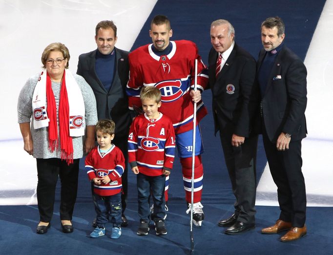 Tomáš Plekanec se stříbrnou hokejkou, kterou obdržel za 1000 zápasů v NHL. Společně s českým hokejistou jsou na fotce jeho maminka, synové, Guy Lefleur i Marc Bergevin.