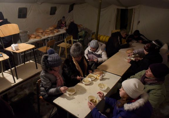 Lidé jedí ve společné jídelně v Avdějevce během bombardování.