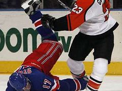 Obránce Denis Gauthier z Philadelphie (vpravo) poslal k zemi útočníka NY Rangers Petra Sýkoru.