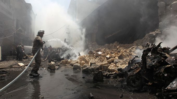 Člen civilních obranných jednotek hasí požár po bombradování syrského města Idlib.