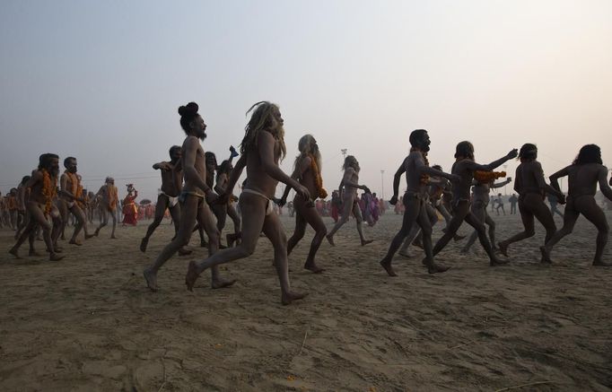 Naga Sadhus or Hindu holymen run to take a holy dip during the first "Shahi Snan" (grand bath) at the ongoing "Kumbh Mela", or Pitcher Festival, in the northern Indian city of Allahabad January 14, 2013. Upwards of a million elated Hindu holy men and pilgrims took a bracing plunge in India's sacred Ganges river to wash away lifetimes of sins on Monday, in a raucous start to an ever-growing religious gathering that is already the world's largest. REUTERS/Ahmad Masood (INDIA - Tags: RELIGION SOCIETY) TEMPLATE OUT Published: Led. 14, 2013, 8:37 dop.