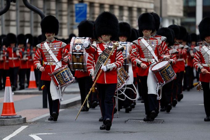 Příprava na korunovaci. Britští vojáci ve slavnostních uniformách pochodují přes Westminsterský most.