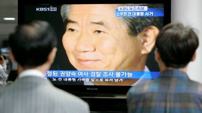 Lidé sledují zprávy, v nichž se mluví o smrti exprezidenta Ro, na hlavním nádraží v Soulu.