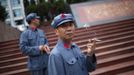 A visitor dressed as a red army soldier smokes as he poses for a picture in Jinggangshan, Jiangxi province September 20, 2012. Jinggangshan, is where former Chinese leader Mao Zedong's career as a revolutionary began to take off. In 1927, Mao and several communist leaders fled with a few thousands to the hills of Jinggangshan, hounded and outnumbered by Nationalist forces. REUTERS/Carlos Barria (CHINA - Tags: POLITICS SOCIETY) Published: Zář. 20, 2012, 5:19 dop.