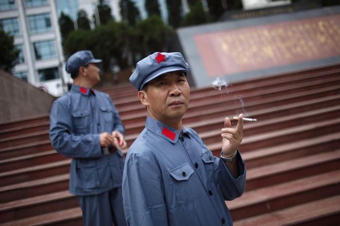 A visitor dressed as a red army soldier smokes as he poses for a picture in Jinggangshan, Jiangxi province September 20, 2012. Jinggangshan, is where former Chinese leader Mao Zedong's career as a revolutionary began to take off. In 1927, Mao and several communist leaders fled with a few thousands to the hills of Jinggangshan, hounded and outnumbered by Nationalist forces. REUTERS/Carlos Barria (CHINA - Tags: POLITICS SOCIETY) Published: Zář. 20, 2012, 5:19 dop.