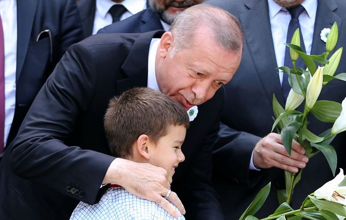 REFILE - QUALITY REPEAT Turkey's President Recep Tayyip Erdogan speaks to a boy at a convoy carrying remains of the Srebrenica genocide victims, in Sarajevo, Bosnia and H