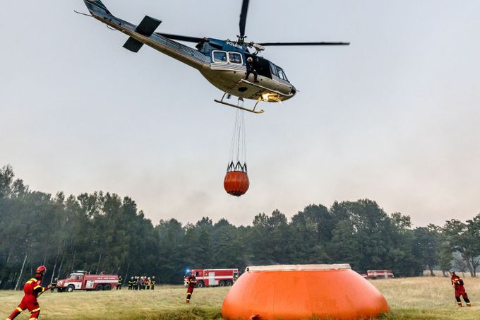 Policejní vrtulník během nasazení při hašení požáru v NP České Švýcarsko. 27. 7. 2022