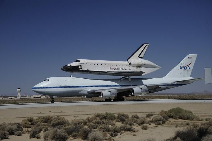 The space shuttle Endeavour, carried piggyback atop a Boeing 747 jumbo jet, comes in for its landing at at Edwards Air Force Base in California, September 20, 2012, after a cross-country trip to Los Angeles to begin its final mission as a museum exhibit. Endeavour is scheduled to take off for its final ferry flight again on Friday, and the final airborne journey of the entire space shuttle fleet, headed for Los Angeles International Airport. REUTERS/Gene Blevins (UNITED STATES - Tags: TRANSPORT SCIENCE TECHNOLOGY) Published: Zář. 20, 2012, 10:14 odp.