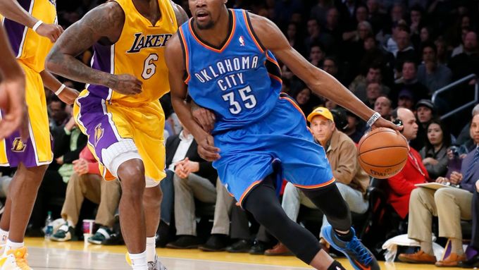Kevin Durant z týmu Oklahoma City uniká Earlu Clarkovi z Los Angeles Lakers