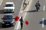 Prodavač červených balonků na teheránské silnici.