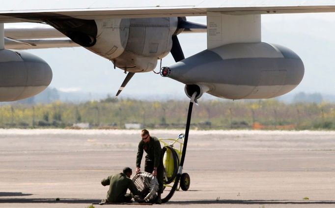 Pozemní personál kontroluje mechaniku na doplňování paliva pro stroje Lockheed C-130 Hercules na základně NATO na Sicílii.