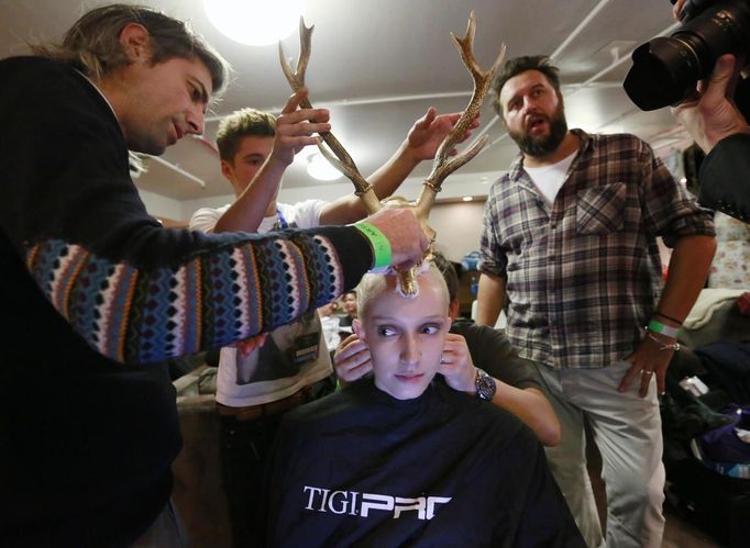 The TIGI creative team work backstage to mount antlers onto a model's head in the TIGI dressing room at the 30th anniversary of the Alternative Hair Show at the Royal Albert Hall in London October 14, 2012. REUTERS/Olivia Harris (BRITAIN - Tags: SOCIETY FASHION) Published: Říj. 15, 2012, 2:03 dop.