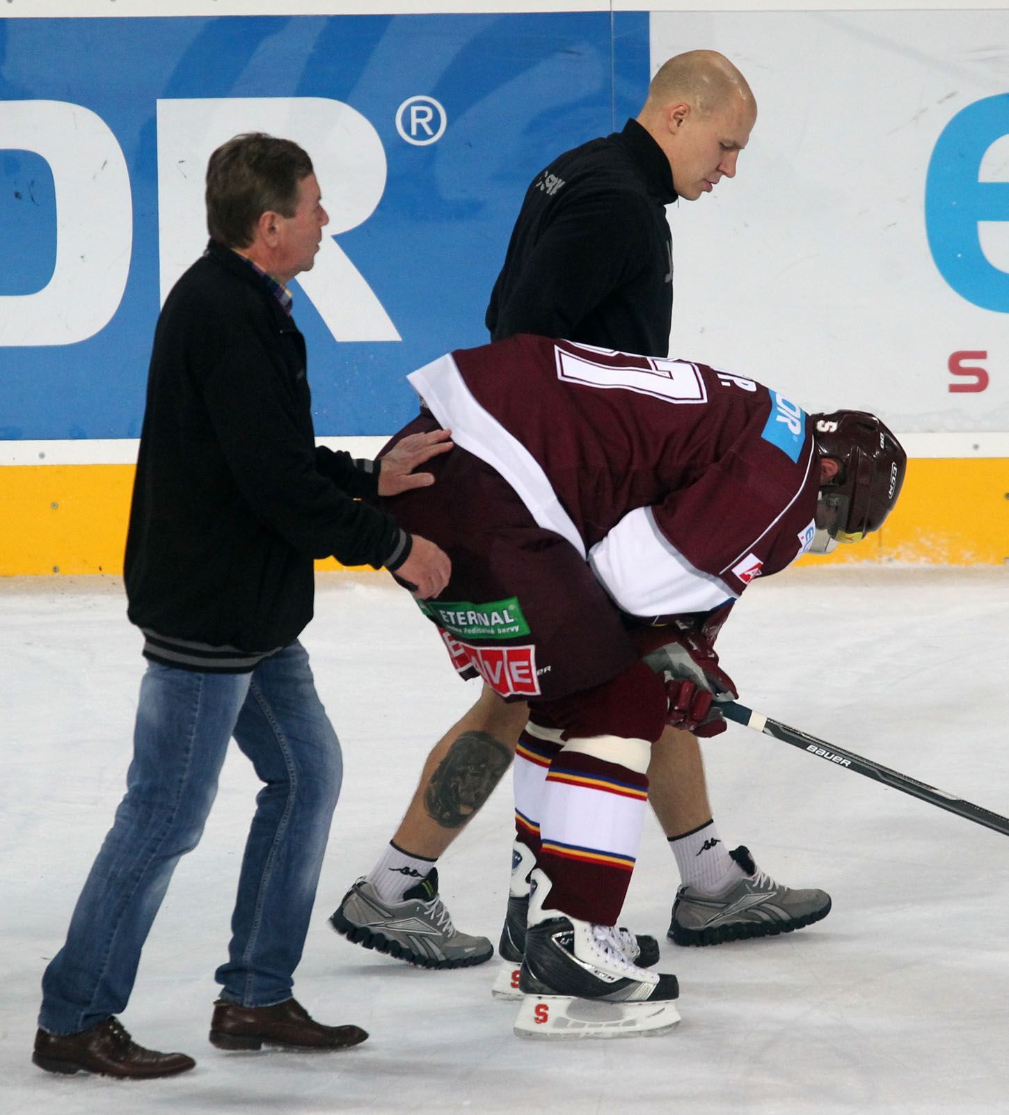 Hokejista Sparty Praha Petr Ton odjíždí v bolestech na střídačku v utkání 8. kola Tipsport extraligy 2012/13 se Zlínem.