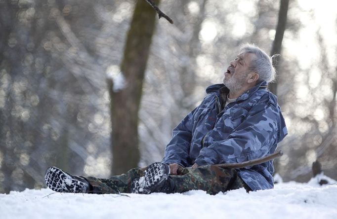 Wolf researcher Werner Freund howls while sitting in an enclosure for Arctic wolves at Wolfspark Werner Freund, in Merzig in the German province of Saarland January 24, 2013. Freund, 79, a former German paratrooper, established the wolf sanctuary in 1972 and has raised more than 70 animals over the last 40 years. The wolves, acquired as cubs from zoos or animal parks, were mostly hand-reared. Spread over 25 acres, Wolfspark is currently home to 29 wolves forming six packs from European, Siberian, Canadian, Artic and Mongolian regions. Werner has to behave as the wolf alpha male of the pack to earn the other wolves respect and to be accepted. Picture taken January 24, 2013. REUTERS/Lisi Niesner (GERMANY - Tags: ANIMALS SOCIETY) Published: Led. 26, 2013, 2:45 odp.