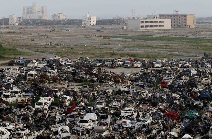 Hromada automobilů, zničených při zemětřesení a tsunami 11. března, leží ve zničené části města Rikuzentakata.