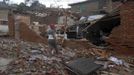 A woman stands outside her house, damaged by Hurricane Sandy, in Santiago de Cuba October 25, 2012. Strengthening rapidly after tearing into Jamaica and crossing the warm Caribbean Sea, Sandy hit southeastern Cuba early on Thursday with 105-mph winds that cut power and blew over trees across the city of Santiago de Cuba. Reports from the city of 500,000 people, about 470 miles (750 km) southeast of Havana spoke of significant damage, with many homes damaged or destroyed. REUTERS/Miguel Rubiera/Cuban Government National Information Agency - AIN/Handout (CUBA - Tags: ENVIRONMENT DISASTER TPX IMAGES OF THE DAY) FOR EDITORIAL USE ONLY. NOT FOR SALE FOR MARKETING OR ADVERTISING CAMPAIGNS. THIS IMAGE HAS BEEN SUPPLIED BY A THIRD PARTY. IT IS DISTRIBUTED, EXACTLY AS RECEIVED BY REUTERS, AS A SERVICE TO CLIENTS Published: Říj. 25, 2012, 6:23 odp.