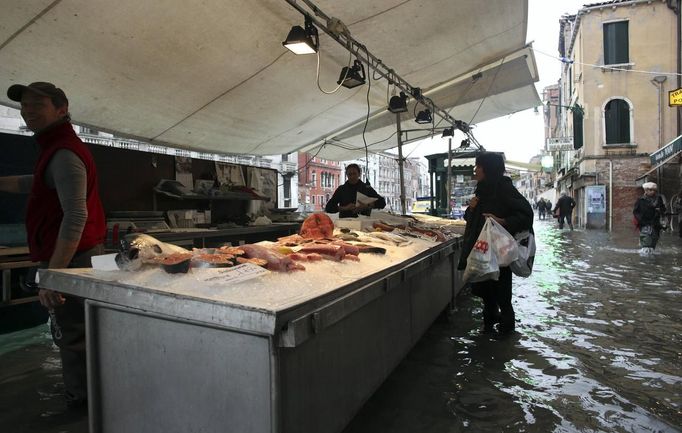 A woman buys fish at a local market during a period of seasonal high water in Venice October 27, 2012. The water level in the canal city rose to 127 cm (50 inches) above the normal level, according to the monitoring institute. REUTERS/Manuel Silvestri (ITALY - Tags: ENVIRONMENT SOCIETY TRAVEL FOOD) Published: Říj. 27, 2012, 12:22 odp.