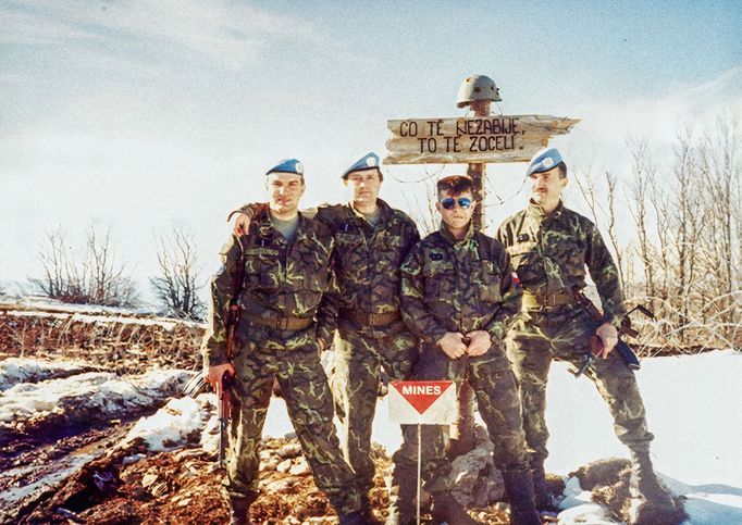 Skupinové foto příslušníků čety pod výstižným nápisem „Co tě nezabije, to tě posílí“. Mise UNPROFOR na území bývalé Jugoslávie. Archivní snímek z roku 1993