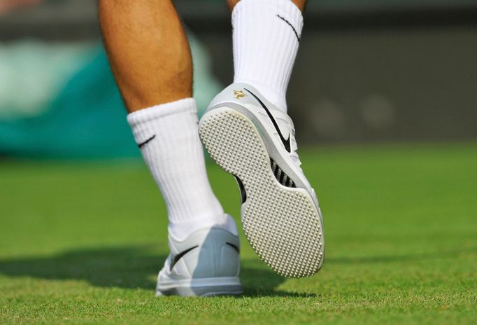 Roger Federer of Switzerland wears new shoes for his men's singles tennis match against Sergiy Stakhovsky of Ukraine at the Wimbledon Tennis Championships, in London June