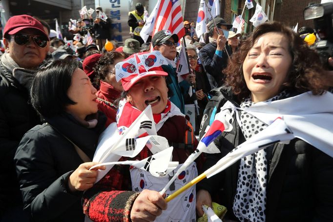 Lidé před soudní budovou reagují na odvolání jihokorejské prezidentky Pak Kun-hje z funkce.