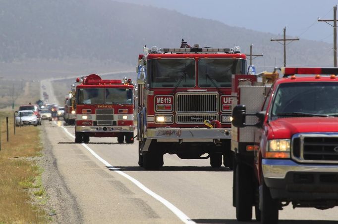 A line of fire trucks make their way down US highway 89 toward the Wood Hollow Fire north of Fairview, Utah, June 26, 2012. More than 500 structures have been threatened by the Wood Hollow fire, forcing up to 1,500 people from homes. REUTERS/George Frey (UNITED STATES - Tags: ENVIRONMENT DISASTER) Published: Čer. 26, 2012, 10:07 odp.