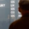 A couple looks at cancelled flights of Lufthansa on flight schedule board at Vienna's airport in Schwechat