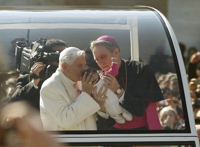 Pope Benedict XVI blesses a baby as he rides around St Peter's Square to hold his last general audience at the Vatican February 27, 2013. The weekly event which would normally be held in a vast auditorium in winter, but has been moved outdoors to St. Peter's Square so more people can attend. The pope has two days left before he takes the historic step of becoming the first pontiff in some six centuries to step down instead of ruling for life. REUTERS/Max Rossi (VATICAN - Tags: RELIGION) Published: Úno. 27, 2013, 10:13 dop.