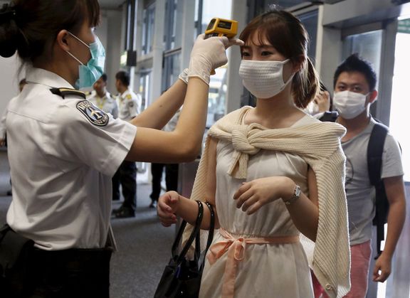 Kontrola teploty pasažérů letadla, které dorazilo z Jižní Korey do Hongkongu.