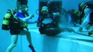 French athlete Philippe Croizon (C), whose arms and legs were amputated after an electric shock accident in March 1994, swims next to unidentified divers in a 33 metre (36 yard) deep pool, the world's deepest pool built to train professional divers, at Nemo33 diving centre in Brussels January 10, 2013. Croizon, who swam with adapted prostheses that had fins attached, broke a world record and became the first disabled person to dive to 33 metres, according to the organisers. REUTERS/Yves Herman (BELGIUM - Tags: SOCIETY SPORT DIVING) Published: Led. 10, 2013, 4:32 odp.