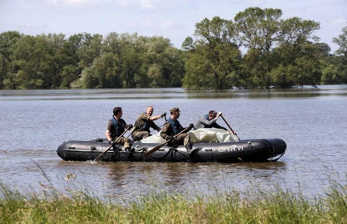 German Bundeswehr armed forces soldiers use a boat as they check a damaged dyke at the river Elbe at the village of Hohengoehren, north of Magdeburg June 10, 2013. Tens of thousands of people have been forced to leave their homes and there have been at least a dozen deaths as a result of floods that have hit Germany, Austria, Slovakia, Poland and the Czech Republic over the past week. REUTERS/Fabrizio Bensch (GERMANY - Tags: DISASTER ENVIRONMENT)