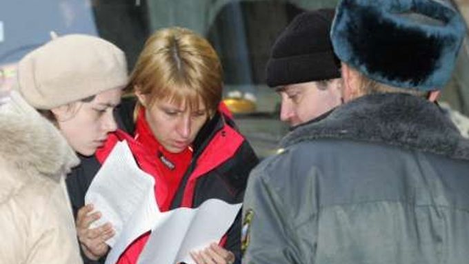 Příbuzní si před moskevskou léčebnou prohlížejí seznam pacientů, kteří se zřejmě stali obětí požáru. Celkem při něm zahynulo 45 žen.