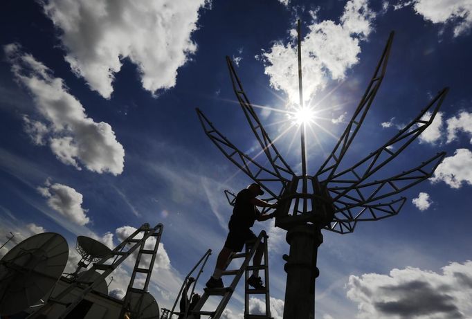 REFILE - CORRECTING TYPO Workers construct satellite dishes for the world's media ahead of the Olympic Games in the London 2012 Olympic Park at Stratford in London July 12, 2012. Preparations for the London Olympics have put Britain's intelligence agencies under significant pressure, as the country stages its largest ever peacetime security operation, British lawmakers said on Thursday. REUTERS/Luke MacGregor (BRITAIN - Tags: SPORT OLYMPICS MILITARY TPX IMAGES OF THE DAY) Published: Čec. 12, 2012, 5:33 odp.