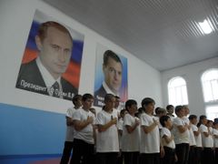 Mladí zápasníci přísahají pod plakáty s Vladimirem Putinem a Dmitrijem Medveděvem.