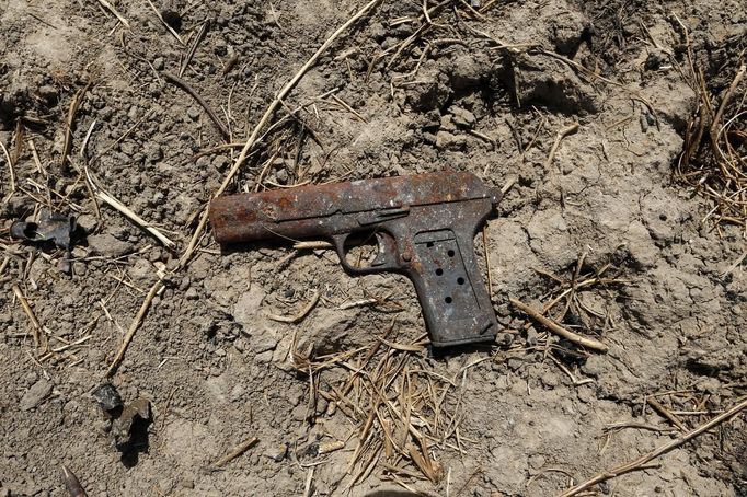 A gun is pictured near a destroyed vehicle used by Islamist rebels on the road between Diabaly and Timbuktu in Mali January 30, 2013. REUTERS/Benoit Tessier (MALI - Tags: POLITICS CONFLICT) Published: Led. 30, 2013, 9:30 odp.