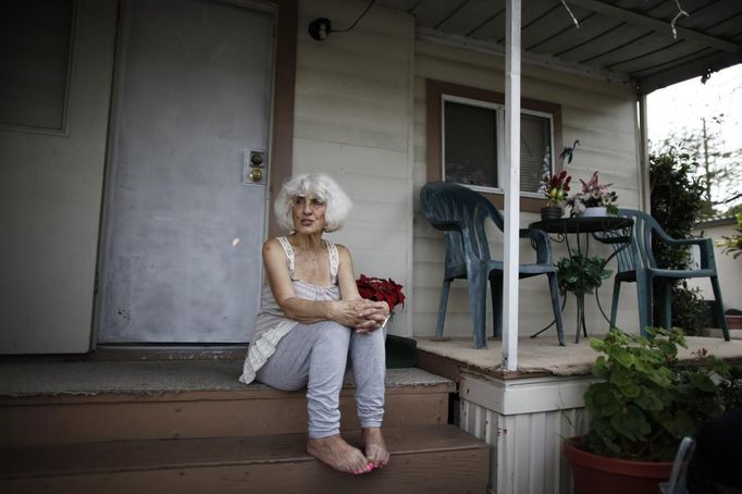 Geri Meeks, 78, sits on the steps of her trailer in which she has lived for 15 years, in Village Trailer Park in Santa Monica, California, July 13, 2012. Developer Marc Luzzatto wants to relocate residents from the trailer park to make way for nearly 500 residences, office space, stores, cafes and yoga studios, close to where a light rail line is being built to connect downtown Los Angeles to the ocean. Village Trailer Park was built in 1951, and 90 percent of its residents are elderly, disabled or both, according to the Legal Aid Society. Many have lived there for decades in old trailers which they bought. The property is valued at as much as $30 million, according the LA Times. REUTERS/Lucy Nicholson (UNITED STATES - Tags: REAL ESTATE BUSINESS SOCIETY POLITICS) Published: Čec. 14, 2012, 7:49 dop.