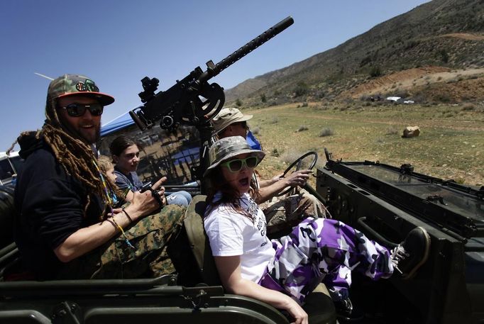 REFILE - CORRECTS FAMILY RELATIONSHIP Danny Josephson (L) and his wife Jesse (R) ride in his father Kent Josephson's 1953 Willys Jeep with a Browning .30 caliber machine gun attached at the center during the Big Sandy Shoot in Mohave County, Arizona, March 23, 2013. The Big Sandy Shoot is the largest organized machine gun shoot in the United States attended by shooters from around the country. Vintage and replica style machine guns and cannons are some of the weapons displayed during the event. Picture taken March 22, 2013. REUTERS/Joshua Lott (UNITED STATES - Tags: SOCIETY) Published: Bře. 25, 2013, 4:59 odp.