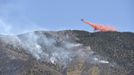 An airplane drops fire retardant along a mountain ridge near Eagle Mountain, Utah, June 23, 2012. A raging Utah brush fire ignited by target shooting in dry grass has forced some 8,000 people from their homes in two small communities since June 22 as high winds fanned flames toward a nearby explosives factory, authorities said. REUTERS/Jeff McGrath (UNITED STATES - Tags: ENVIRONMENT DISASTER) Published: Čer. 23, 2012, 8:50 odp.