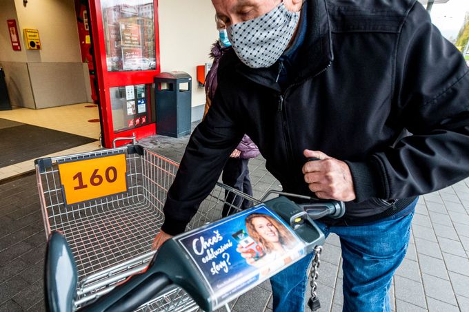 Zákazník si bere očíslovaný nákupní vozík před hypermarketem v Ústí nad Labem.