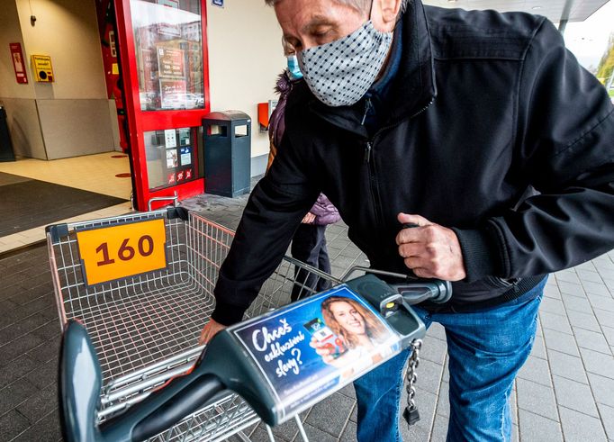 Zákazník si bere očíslovaný nákupní vozík před hypermarketem v Ústí nad Labem.