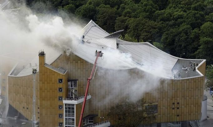 Smoke rises from the roof of the Berlin Philharmonie near Potsdamer Platz, as the firebrigade attempt to extinguish a fire inside the building, in Berlin May 20, 2008. REUTERS/Hannibal Hanschke (GERMANY)