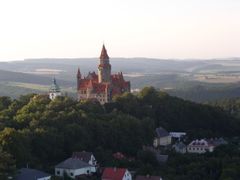 Pohled na hrad Bouzov z ptačí perspektivy tak, jak jej nabízí návštěvníkům oficiální průvodce Bouzovem na stránkách www.hrad-bouzov.cz.
