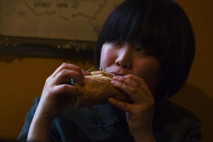 Ritsuko Hatanaka, 23, a practising 'freegan', eats a sandwich made from scavenged food in Vancouver, British Columbia April 11, 2012. A 'Freegan' is someone who gathers edible food from the garbage bins of grocery stores or food stands that would otherwise have been thrown away. Freegans aim to spend little or no money purchasing food and other goods, not through financial need but to try to address issues of over-consumption and excess. Picture taken April 11, 2012. REUTERS/Ben Nelms (CANADA - Tags: SOCIETY) ATTENTION EDITORS PICTURE 12 OF 21 FOR PACKAGE 'DUMPSTER DIVING FOR FOOD' Published: Kvě. 15, 2012, 11:59 dop.